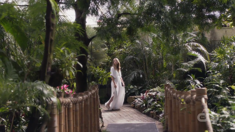 Kara is in a garden in a lovely white dress