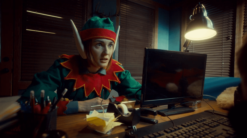 Nicole leans in seriously while wearing her elf costume