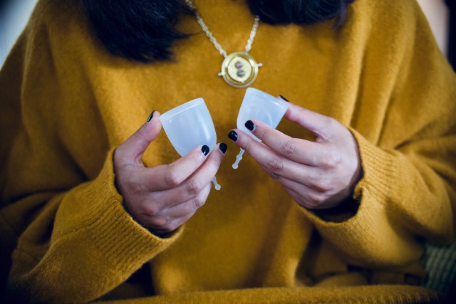 A woman holding the XO Flo Original in her right hand, and the XO Flo Mini in her left, to show scale and size difference.