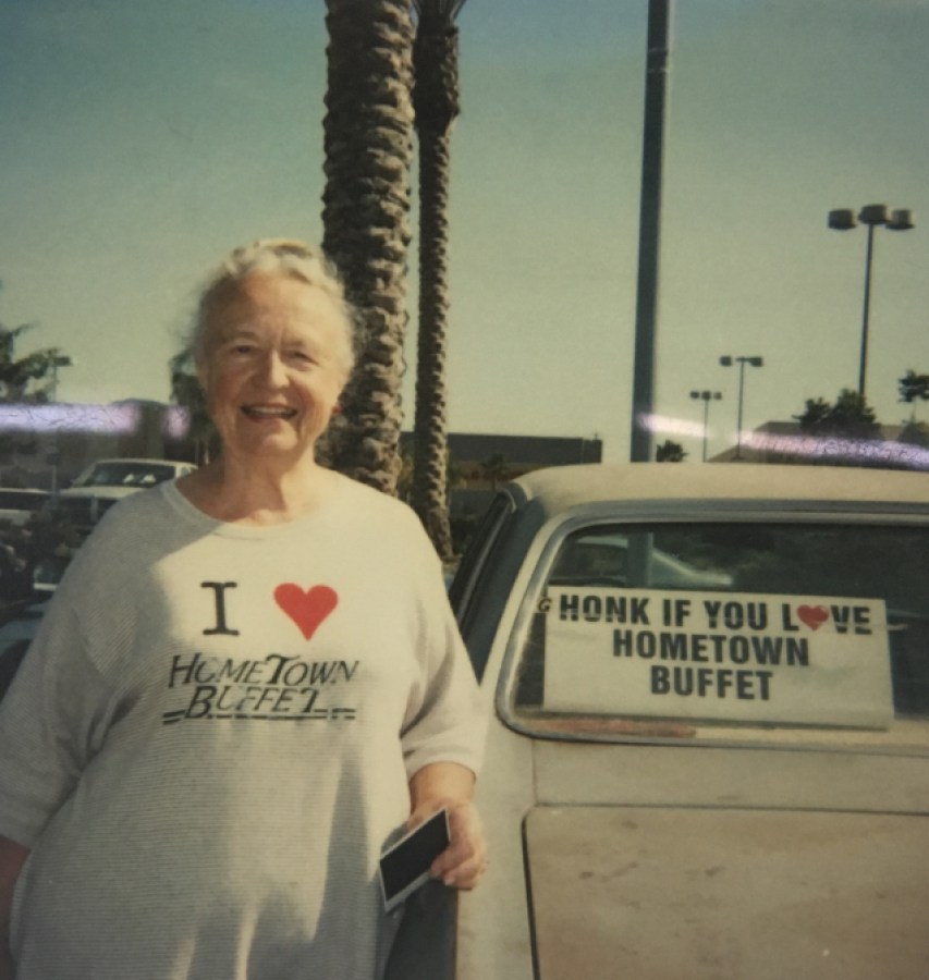 Lisa Ben in an "I Love Hometown Buffet" t-shirt standing next to her car that says HONK IF YOU LOVE HOMETOWN BUFFET