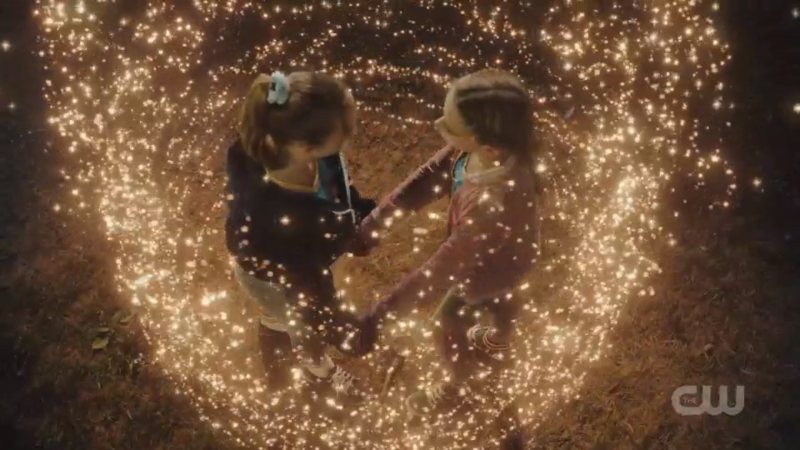 Little Ava and Little Sara hold hands amidst the sparkles