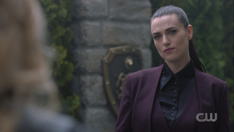 Lena smirks in the garden in her suit