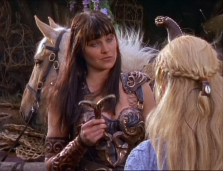 Xena holds a knife and stands in front of Gabrielle on Xena: Warrior Princess