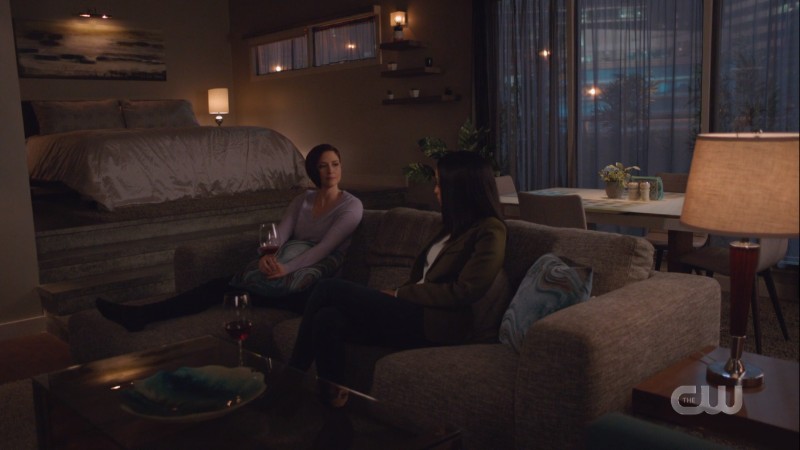 Alex and Kelly are on Alex's couch with red wine