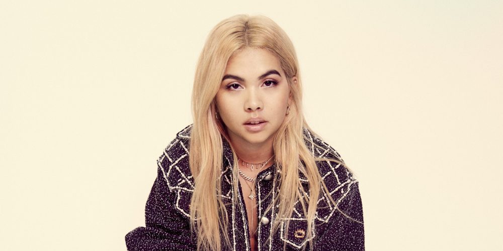 Hayley Kiyoko in front of a yellowish background