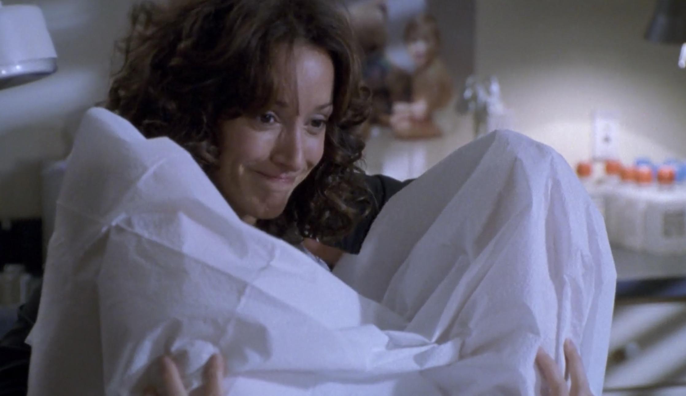 Bette about to go down on Tina who is draped in a hospital gown