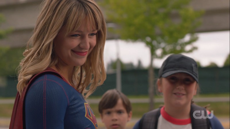 Supergirl smiles at the children she saved