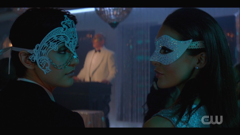 Bess and Lisbeth exchange glances in masquerade masks