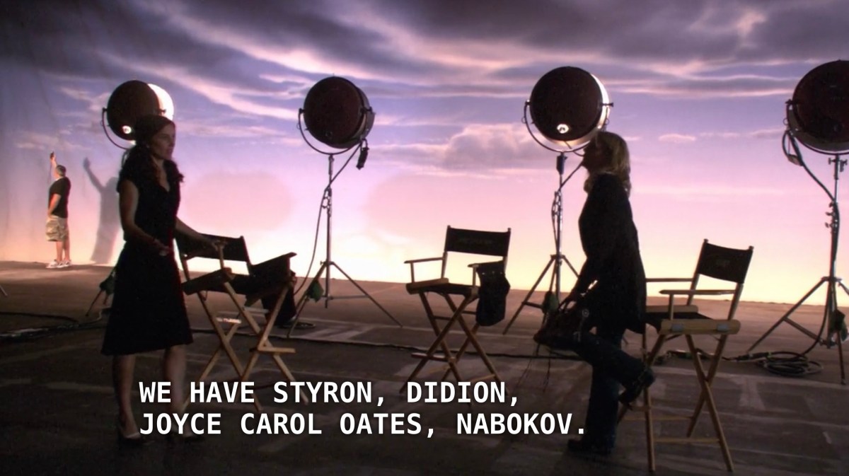 Helena and Tina stand in a big film studio with directors chairs and spotlights shining on a backdrop of clouds. Helena is detailing the success of her publishing company, saying that "We have Styron, Didion, Joyce Carol Oates, Nabokov."