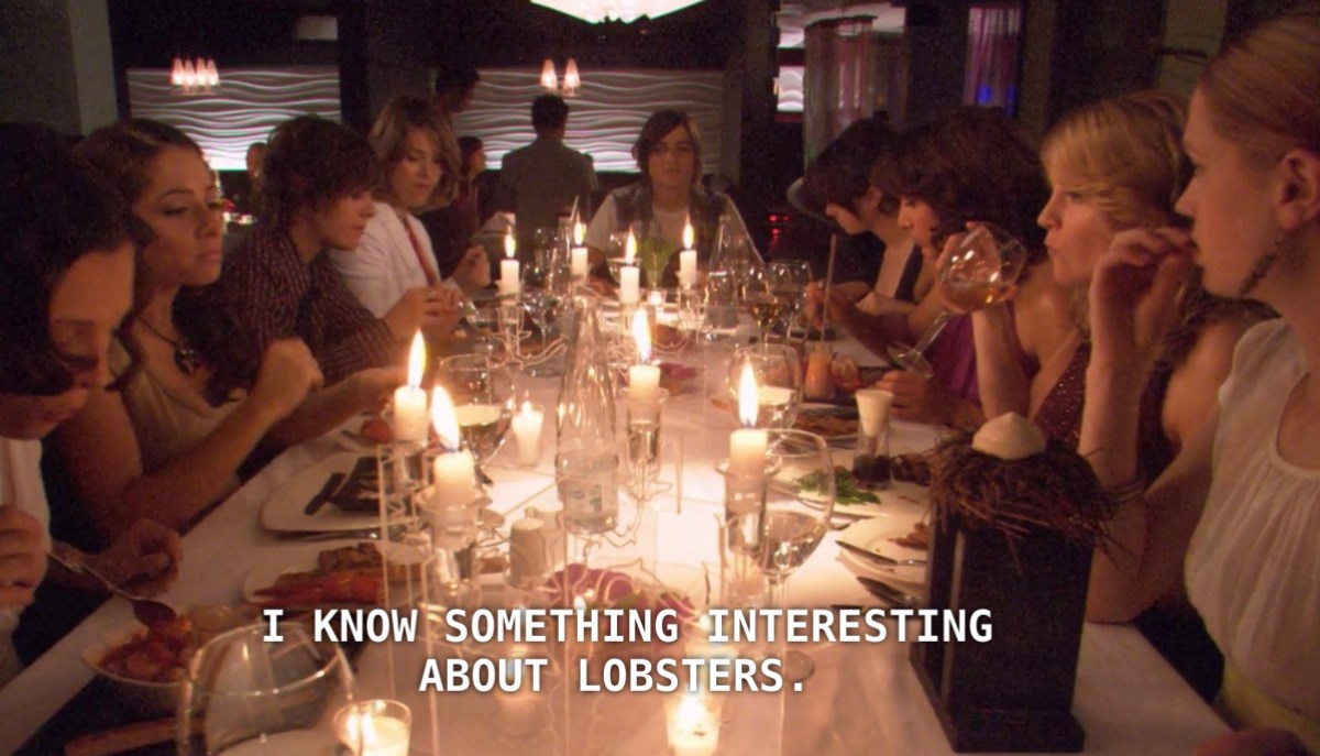 The whole gang sits at a candle-lit restaurant table, everyone eating their respective dinners. Max says "I know something interesting about lobsters."