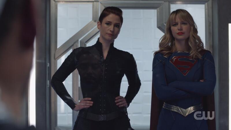 Alex and Kara look sternly upon their prisoner