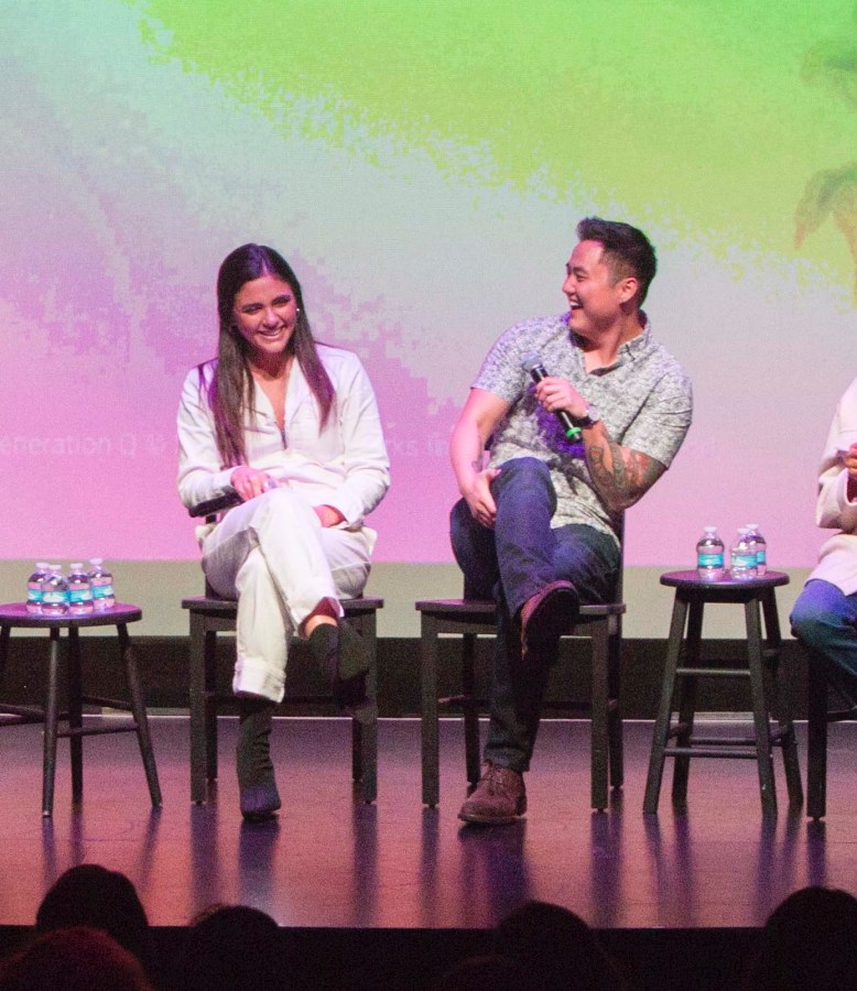 Arienne Mandi and Leo Sheng sit next to each other on stage. They are both laughing.