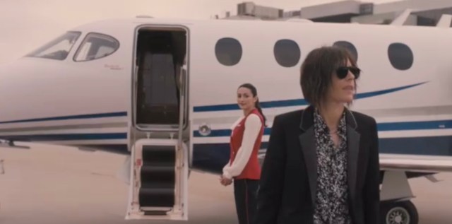 Shane walks off a private jet while a flight attendant watches her go, clearly attracted