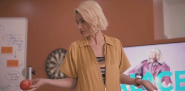 Alice standing in a production meeting, talking to her team about