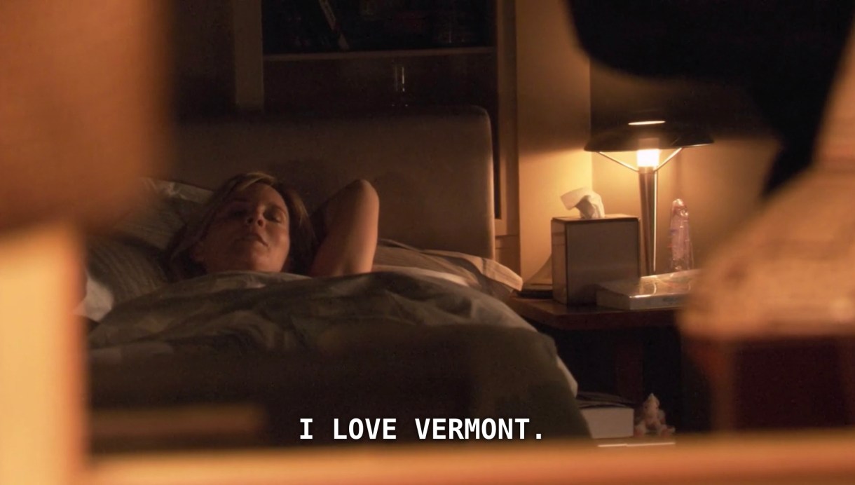 Tina is laying in bed, her arms behind her head, looking at Bette off screen. Tina says, "I love Vermont."