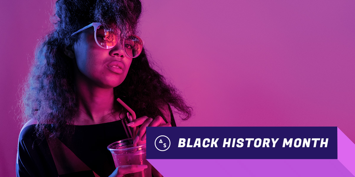 black history month autostraddle - young black woman wearing sunglasses holding cocktail with straw, looking at the camera in an appraising way