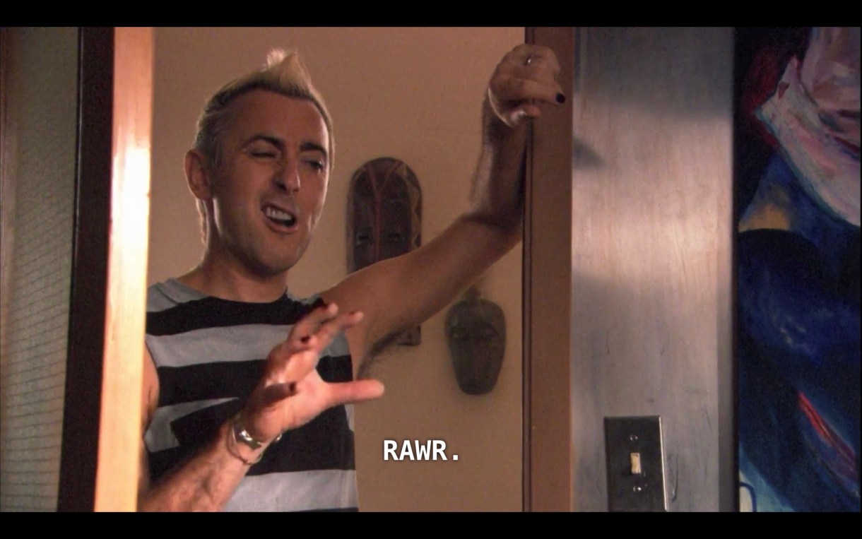 Billie (wearing a black-and-gray horizontal striped tank top, his blonde hair styled into a mohawk), stands in a doorway withe the door half open. He makes his right hand into a claw, winks an eye, and says, "Rawr."