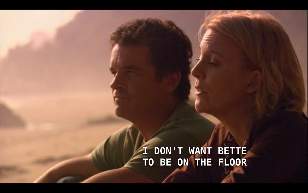 Henry (wearing a green shirt) and Tina (wearing a brown top) are sitting on the beach. Tina says, "I don't want Bette to be on the floor for the next two years," referring to how she doesn't want to hurt Bette by breaking up with her.