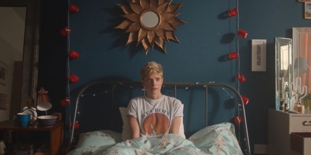 Mae Martin in "Feel Good." Mae Martin is sitting in her bed, in front of a blue wall