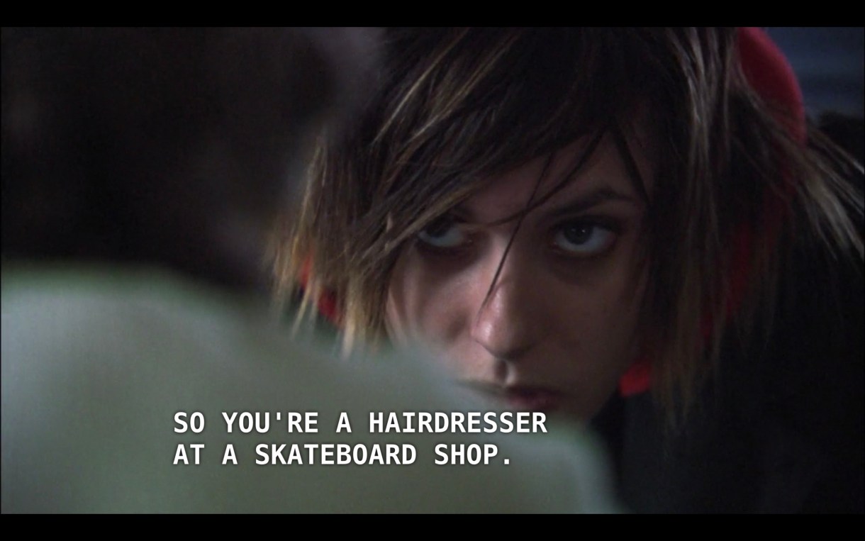 Shane (with blonde tips in her hair) is slouched down and looking at her dad (off screen). Her dad says, "So you're a hairdresser at a skateboard shop."