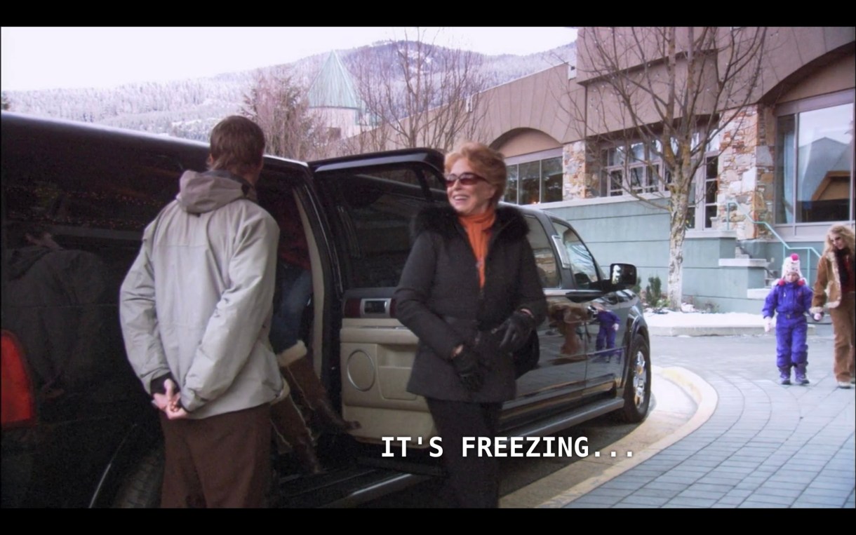 Peggy Peabody (wearing an orange sweater under a black fur-lined coat and black gloves) steps out of a stretch limo. She says, "It's freezing..."