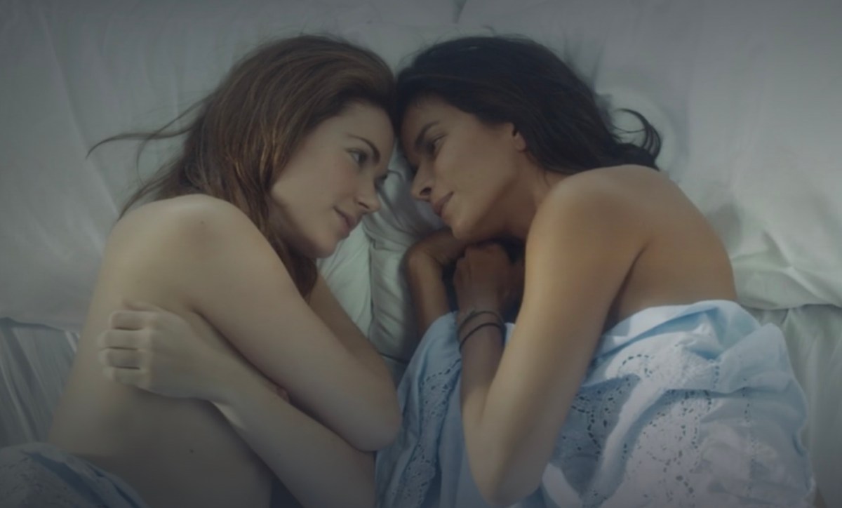 Two women lay together in bed after having sex, pressing their foreheads together. This is a lesbian movie available for streaming on Hulu.