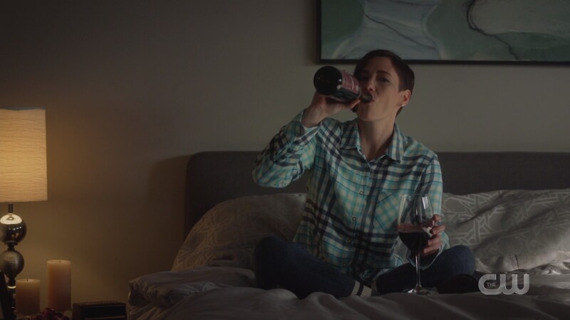 Alex holds a glass of wine but drinks from the bottle