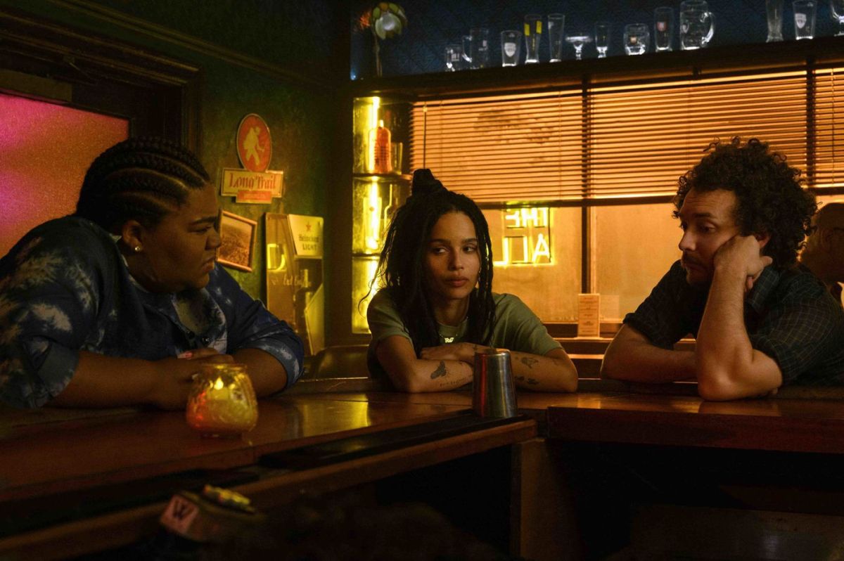 Zoe Kravitz in High Fidelity, sitting at a bar with her buddies looking unhappy