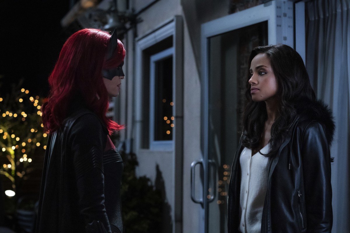 Batwoman in her superhero gear looks at Sophie, her ex-girlfriend. They are standing outside at night.