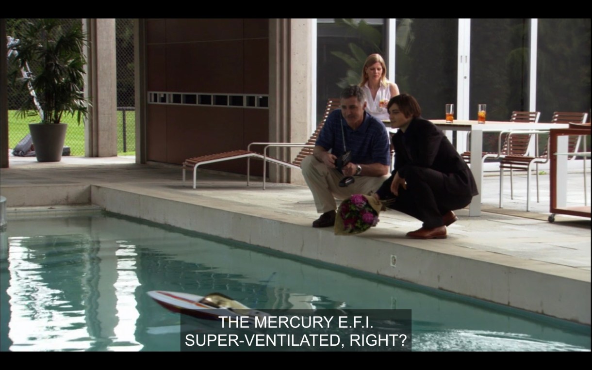 Max and his boss are driving a remote control boat in a pool. Max says, "The Mercury E.F.I. Super ventilated, right?"