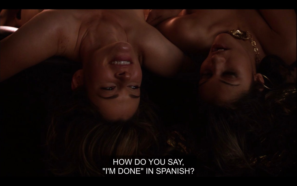 Alice and Papi hang upside down off the side of a bed, naked. Alice says, "How do you say, 'I'm done' in Spanish?"
