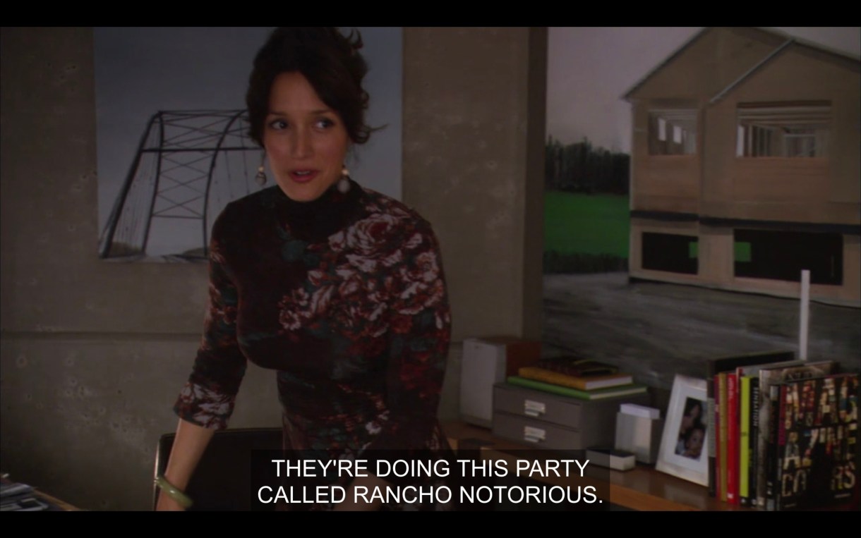 Bette leans on her desk in her office. She says, "They're doing this party called Rancho Notorious."