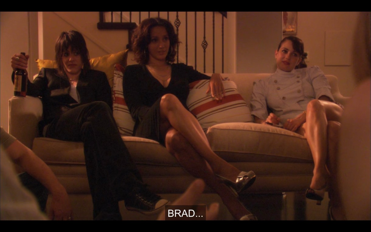 Shane, Bette, and Jenny sit on a couch at Tina and Henry's party, looking bored and annoyed by straight people.