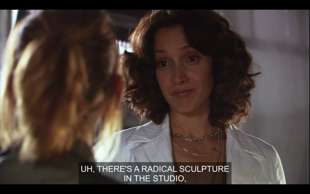 Bette looks at Jodi. Bette looks apprehensive, says, "Uh, there's a radical sculpture in the studio that's crude, and brilliant, and enormous."