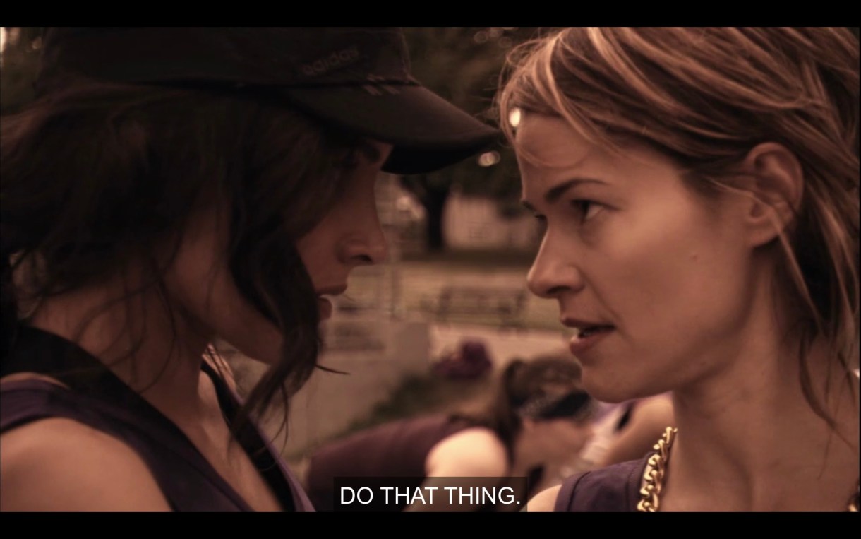 Helena and Alice stand face-to-face looking seriously at each other. Alice says to her, "Do that thing" right before Helena takes a free throw shot.