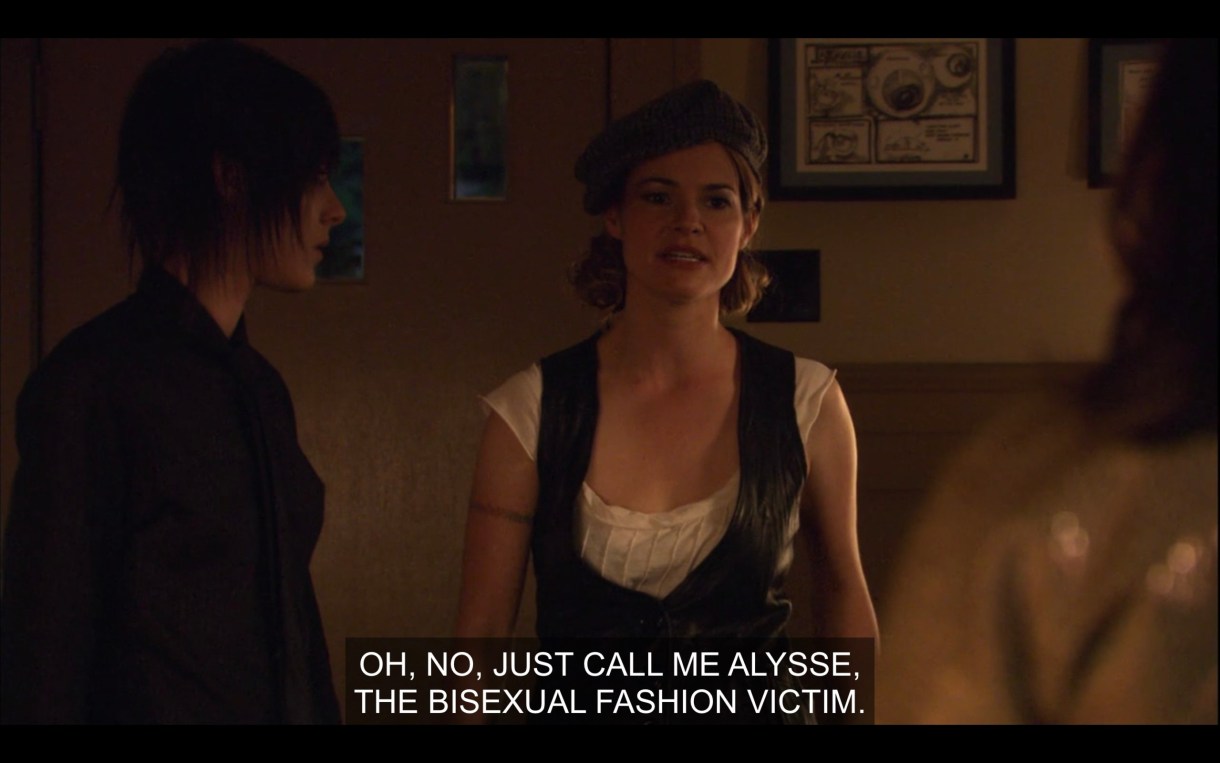 Shane (wearing all black) and Alice (wearing a white top under a black vest) stand in the living room opposite of Jenny, off camera. Alice says, "Oh, no, call me Alysse, the bisexual fashion victim."