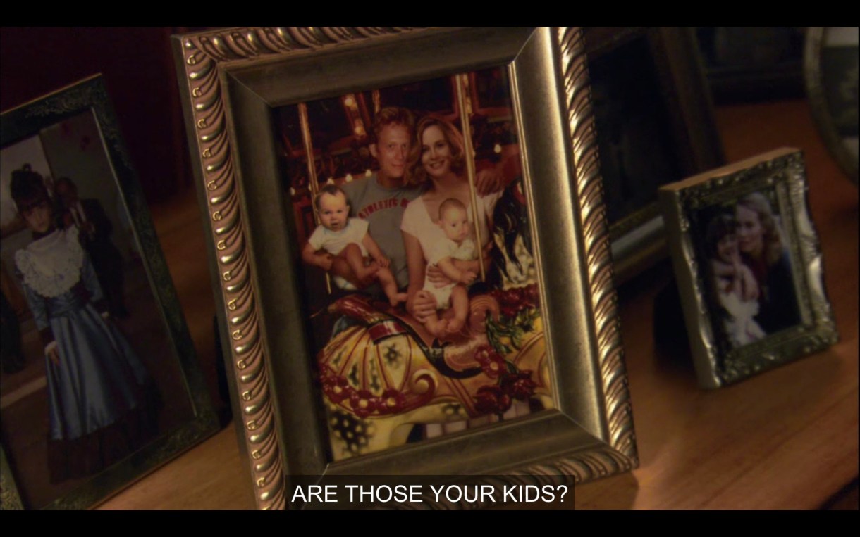 Framed photo of a white couple with two babies on a carousel. "Are those your kids?"