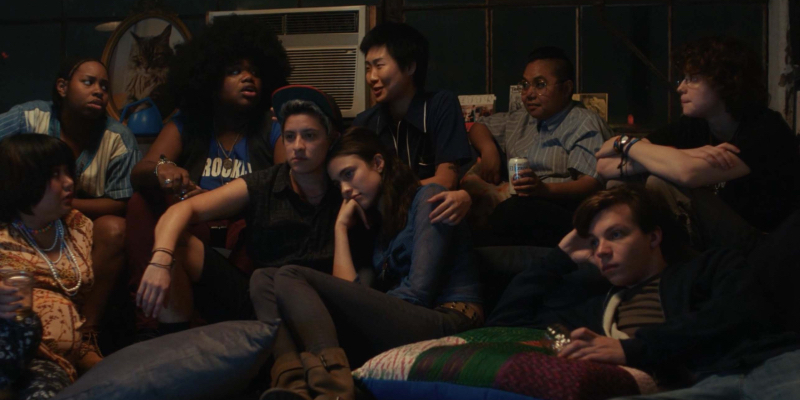 A group of 2006-era queer people sit around watching TV.