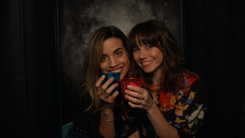 Two young women smiling in a photobooth