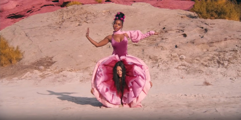 Janelle Monáe in pussy pants with Tessa Thompson's head between her legs.