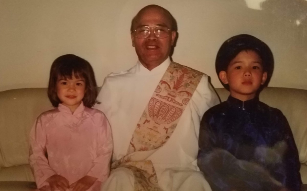 The author is wearing pink and seated next to their and older brother.