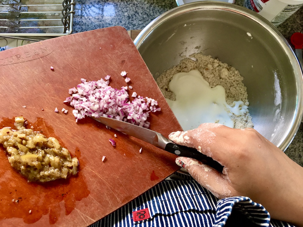 cutting board w onion and preserved lime sliding into bowl of flour