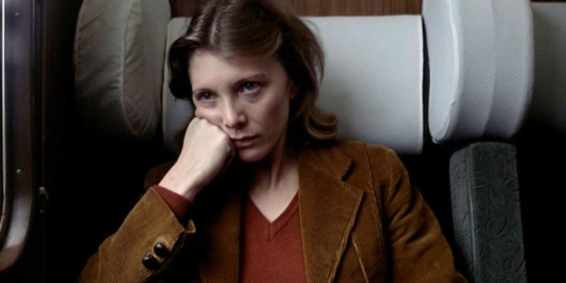 A still from the 28th best lesbian movie of all time Les Rendez-vous d'Anna. A woman on a train rests her head on her hand.