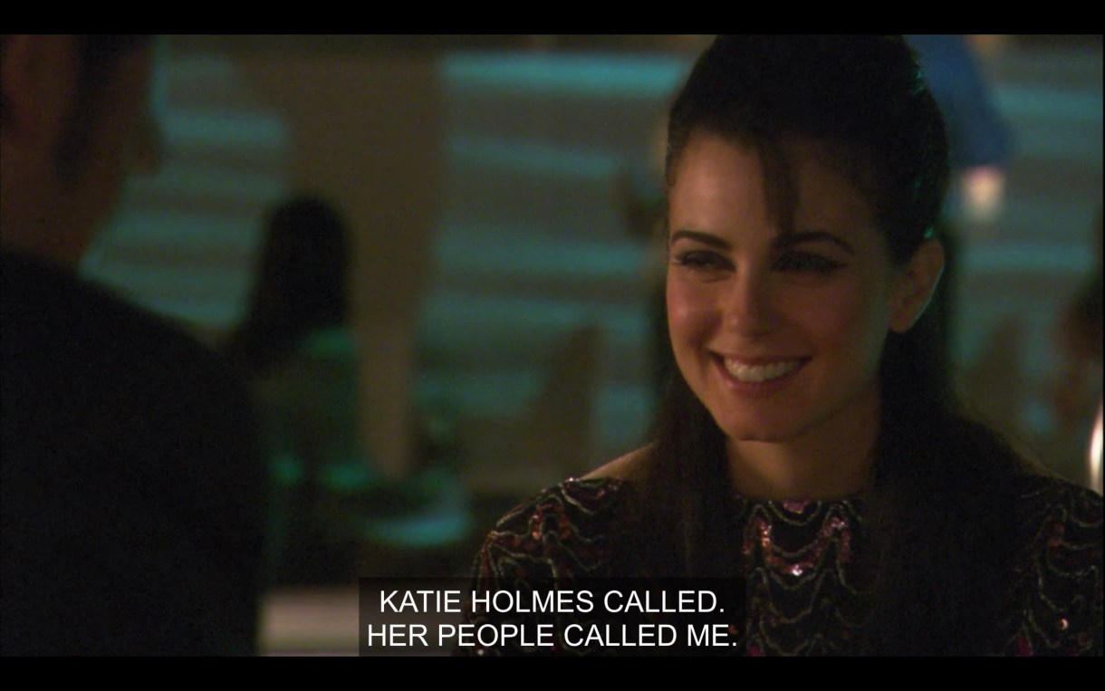 Jenny smiling while somebody says "Katie Holmes called. Her people called me." It's an evening meeting near a pool, but you can really only see Jenny.