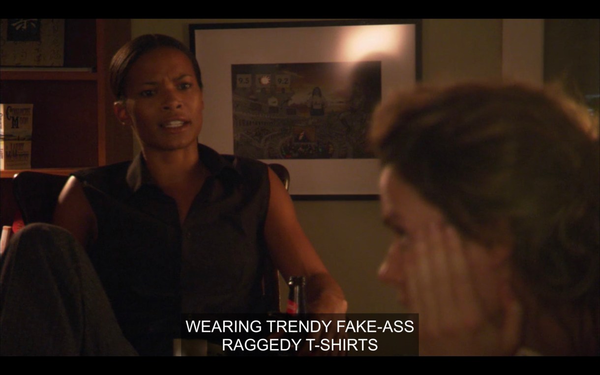 Tasha looks critically at Alice in Alice's apartment. Tasha says, "Wearing trendy fake-ass raggedy t-shirts."