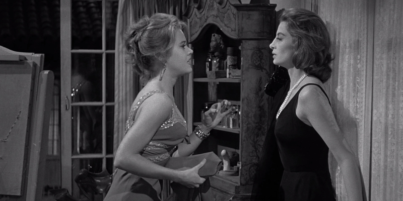 Jane Fonda pleads with Capucine who has her back against a window.