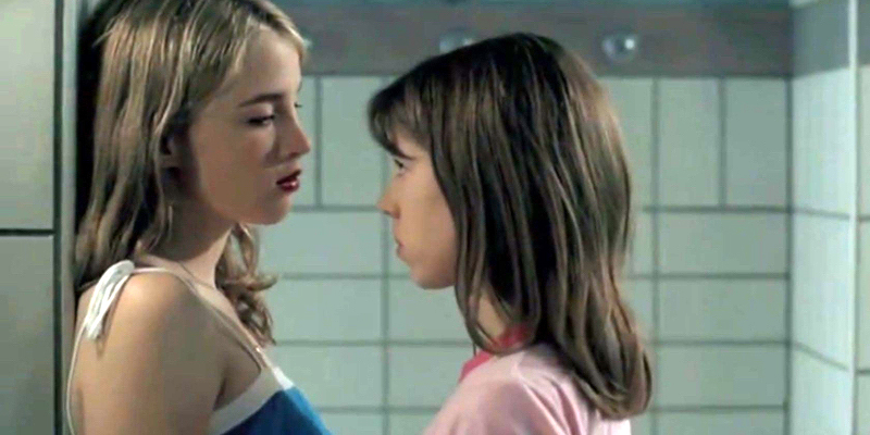 A still from the 25th best lesbian movie of all time Water Lilies. Two girls make eye contact in a school gym shower.