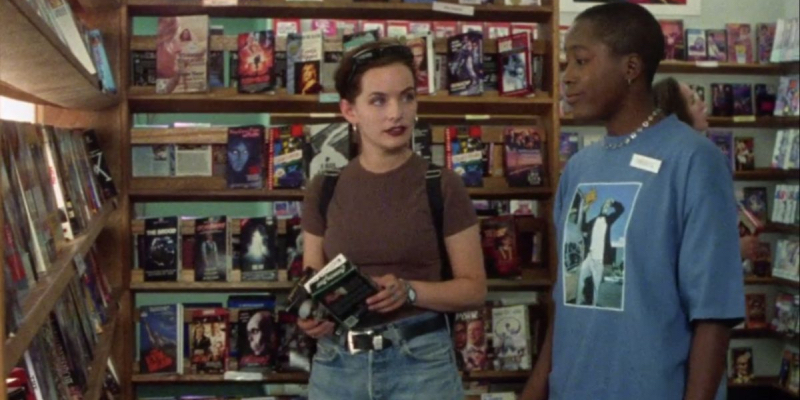A still from the 5th best lesbian movie of all time The Watermelon Woman. Cheryl Dunye stands next to Guinevere Turner in a video store.