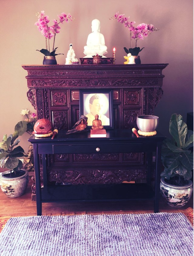 The family shrine, adorned with orchids, incense, and meditation bowls.