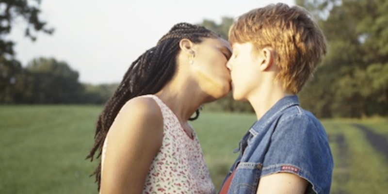 A femme girl and a butch girl kiss. 